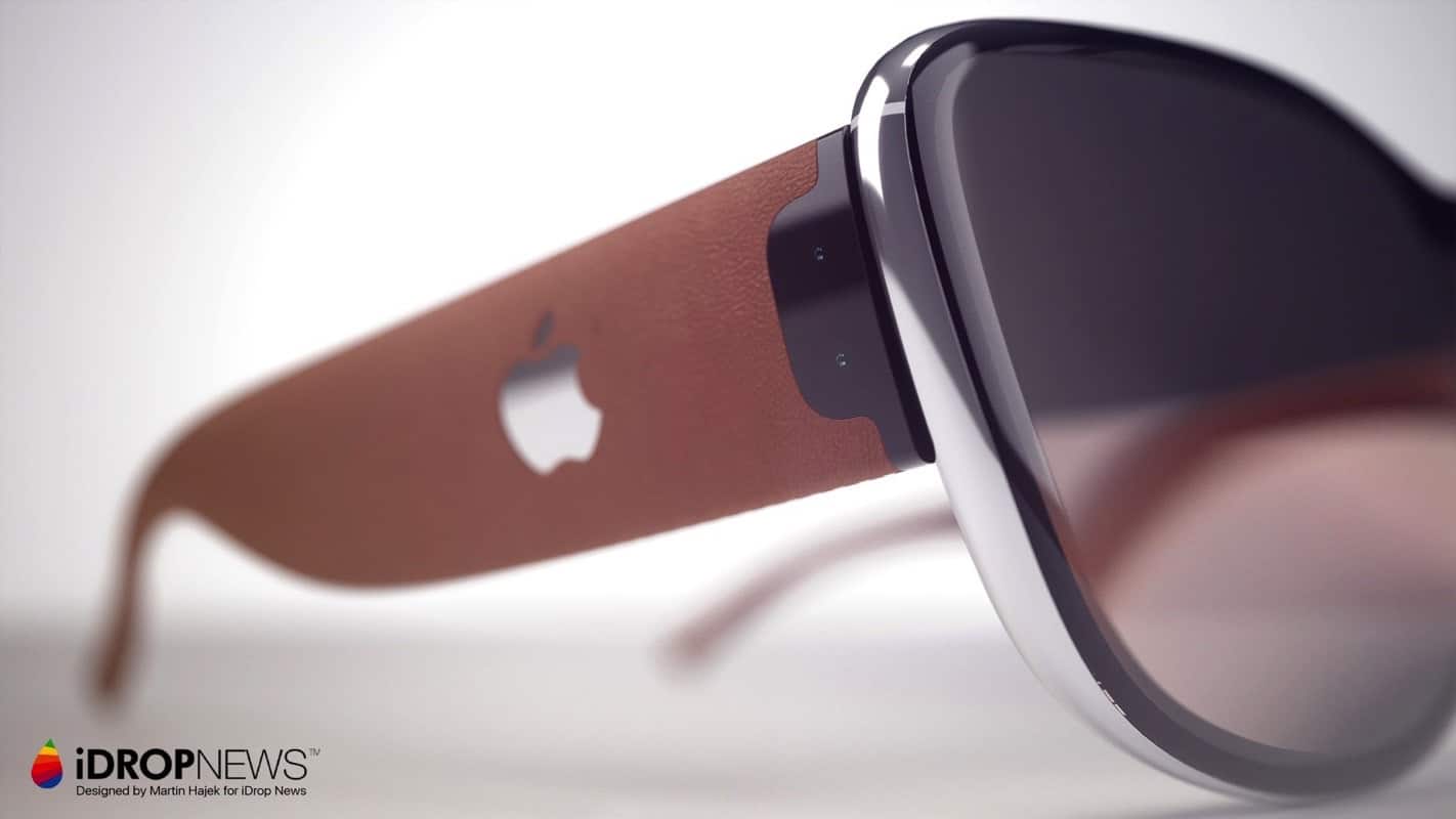 A close-up view of a pair of sleek Apple Glasses with brown frames and a small Apple logo on the side. The image is branded with the iDrop News logo in the lower-left corner. The background is out of focus, highlighting the smart glasses.