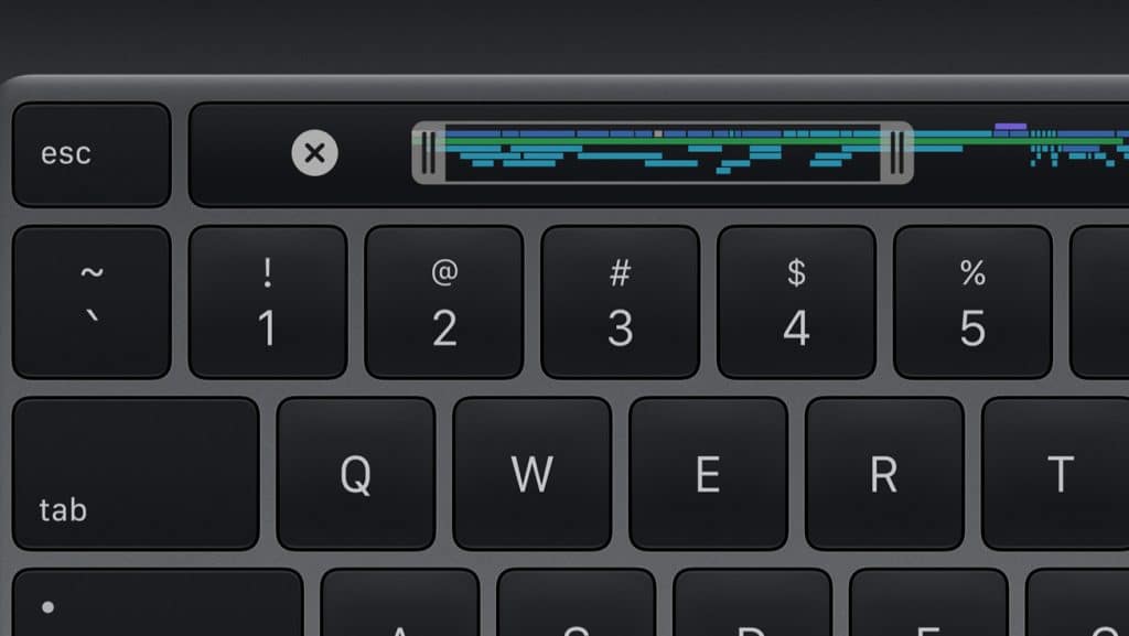 Close-up of a black computer keyboard on a 13-inch MacBook Pro, with the top row of keys including esc, numbers 1 to 4, and QWERT keys visible. Above the keyboard is a touch bar displaying a music editing interface.