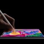 An iPad Mini, powered by the A17 Pro Chip, displays a hand skillfully using a stylus to draw vibrant illustrations of flowers and leaves on its screen against a black background.