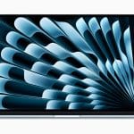 A sleek M4 MacBook Air with a silver body and a black-bordered screen displaying an abstract blue and black spiral pattern. The device is showcased facing forward on a plain white background, highlighting Apple’s embrace of new colors in their design.