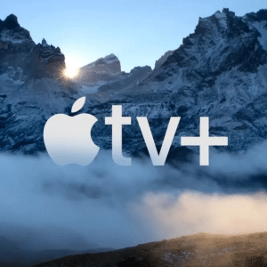 The Apple TV+ logo stands proudly against a majestic backdrop of rugged mountains, partially veiled in snow and mist. Sunlight peeks through the peaks, casting a serene and dramatic glow, perfectly mirroring the innovative spirit of Apple TV+.