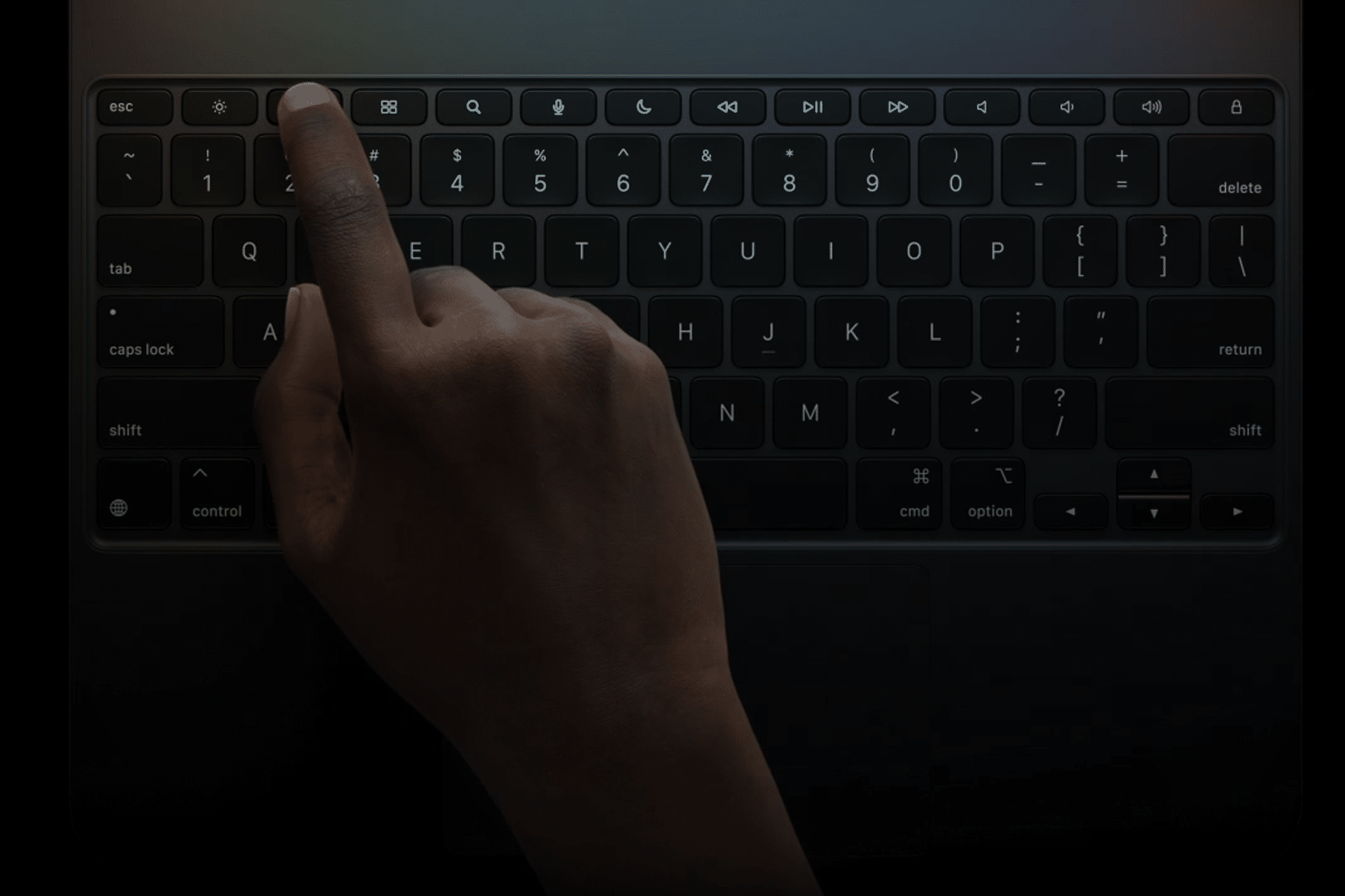 A hand with dark skin presses the escape key on a backlit laptop keyboard in a dimly lit environment, highlighting how essential shortcuts can boost productivity for iPad power users.