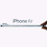 A hand holds a thin smartphone horizontally, with "2026 iPhone Air" displayed above the device against a plain, light background, highlighting its sleek design and dual-lens camera.