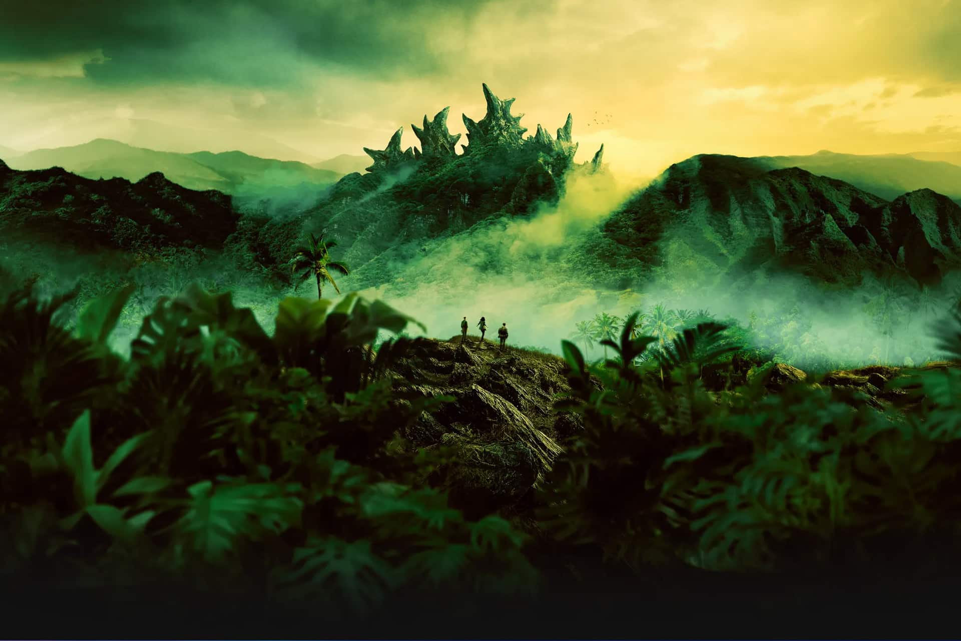 Apple TV Monarch - Three people stand in a lush, misty jungle facing a distant mountain with jagged, fantastical rock formations under a dramatic yellow-green sky. Dense vegetation and palm trees surround them in this cinematic scene inspired by Apple TV Monarch.