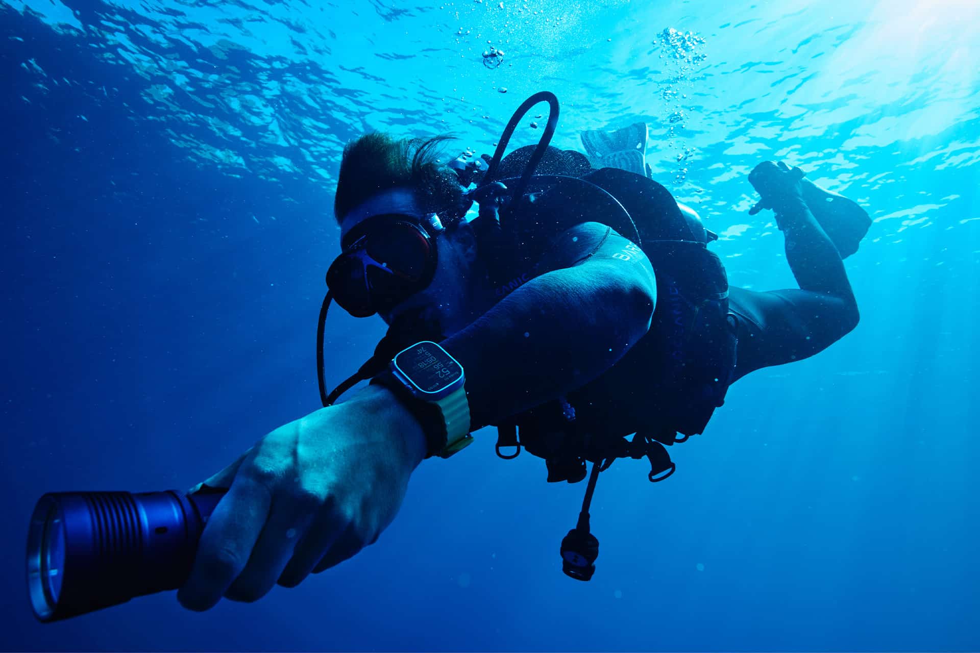 Scuba diver wearing Apple Watch Ultra underwater while diving.