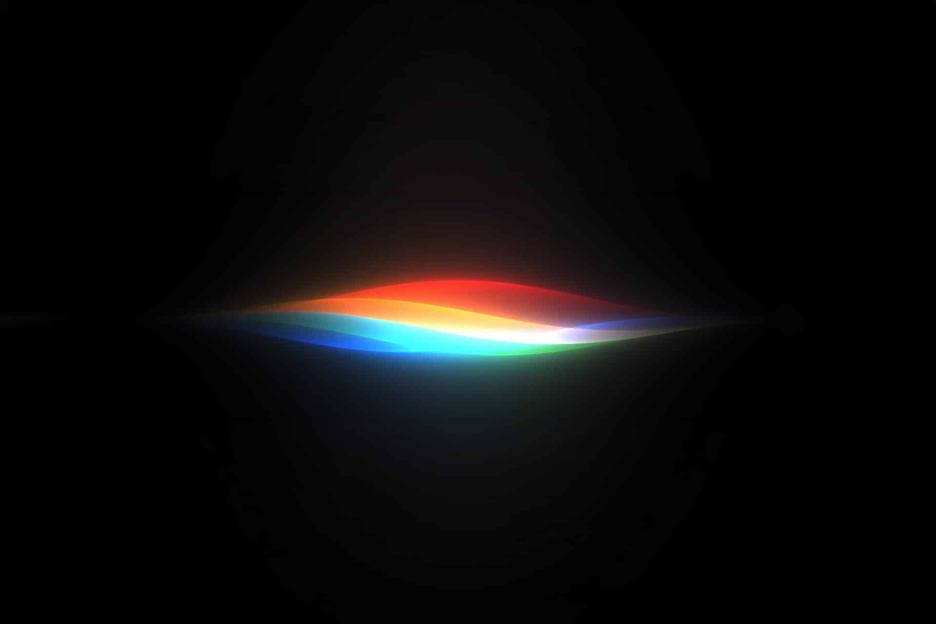 macOS 27 - A glowing, abstract wave of light displaying colors of the rainbow on a black background, with hues blending smoothly from red to violet—evoking the innovative spirit of Apple Intelligence unveiled at WWDC26.
